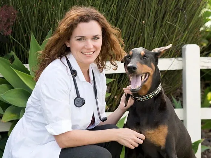 Dr. Laura Putnam, DVM, founder of Bonnie Mara Animal Hospital, outdoors with a dog